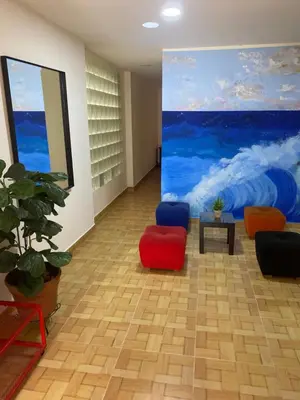 a room with chairs and a painting on the wall at Acogedor loft, para 4 huéspedes Medellín Antioquia in Medellín