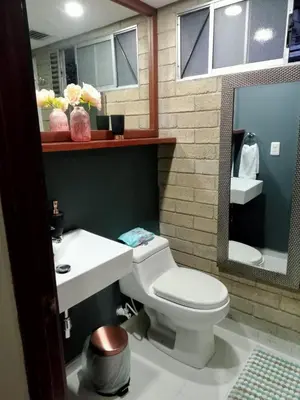 a bathroom with a toilet and a sink and a mirror at Apartment in Palmas - Poblado in Medellín