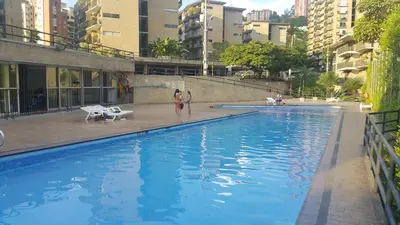 two women standing in a swimming pool in a city at Apartment in Palmas - Poblado in Medellín