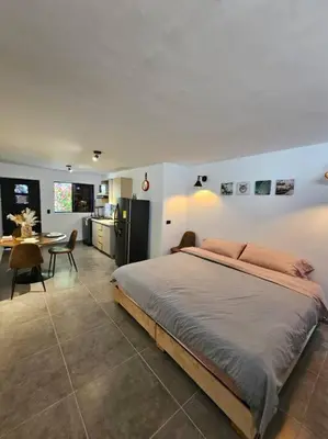 a bedroom with a large bed and a kitchen at Estupendo Loft en El Poblado in Medellín