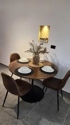 a wooden table with chairs and a table with plates on it at Estupendo Loft en El Poblado in Medellín