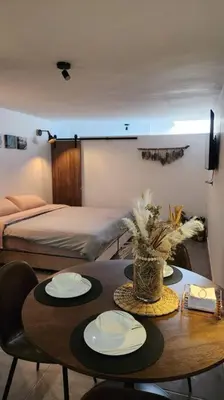 a room with a table with two chairs and a bed at Estupendo Loft en El Poblado in Medellín