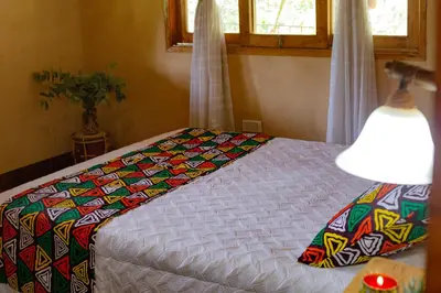 a bed with a colorful quilt on it in a room at Luna Verde Eco Hábitat in Rionegro