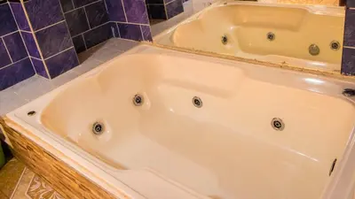 a bath tub in a bathroom with purple tiles at Hotel Quinchia in Quinchía