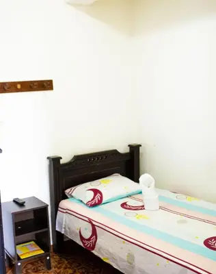 a bedroom with a bed and a small night stand at Hotel Quinchia in Quinchía