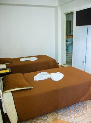 two beds in a hotel room with towels on them at Hotel Quinchia in Quinchía