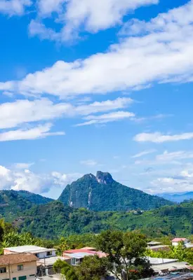 a mountain in the distance with a blue sky and clouds at Hotel Quinchia in Quinchía