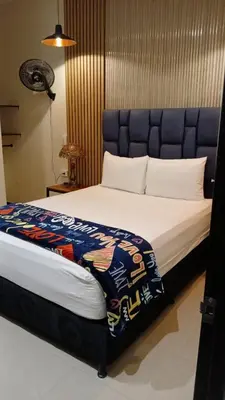 a bedroom with a large bed with a blue headboard at Hotel 50 Suites in Caldas