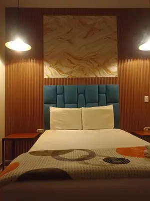 a bedroom with a large bed with a blue headboard at Hotel 50 Suites in Caldas