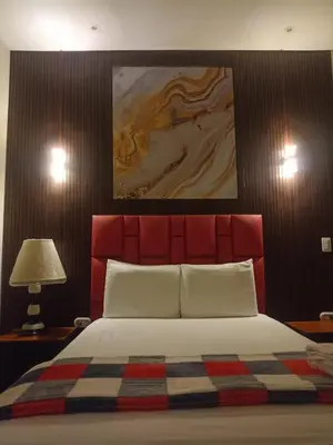 a bedroom with a large bed with a red headboard at Hotel 50 Suites in Caldas