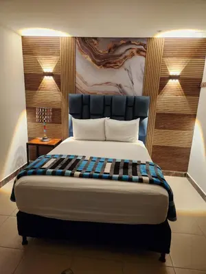 a bedroom with a large bed with a black headboard at Hotel 50 Suites in Caldas