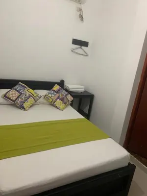 a bedroom with a bed with two pillows and a table at Hotel Los Balcones in Doradal