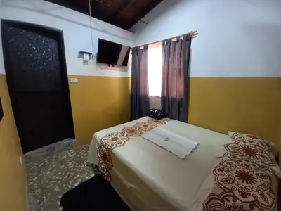 a bedroom with a bed with a towel on it at Hospedaje Ricaribe in Medellín