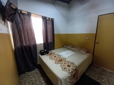 a bedroom with a bed and a window at Hospedaje Ricaribe in Medellín