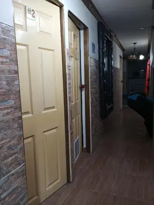 a hallway with a door and a brick wall at Hospedaje Ricaribe in Medellín