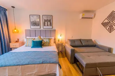 a bedroom with two beds and a couch in it at Hermosa Suite CoWork - Gym-WifI El Poblado in Medellín