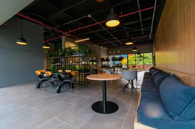 a restaurant with a couch and tables and chairs at Hermosa Suite CoWork - Gym-WifI El Poblado in Medellín