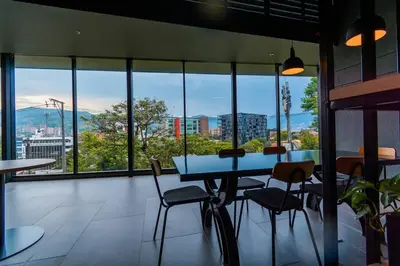 a table and chairs in a room with a view of a city at Hermosa Suite CoWork - Gym-WifI El Poblado in Medellín