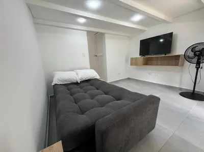 a large couch in a room with a flat screen tv at Loft Zen en Envigado in Envigado