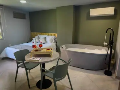 a bedroom with a bed and a tub and a table and chairs at Loft moderno con bañera Medellín 1-03 in Medellín