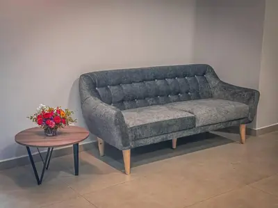 a gray couch sitting next to a table with a vase of flowers at Loft moderno con bañera Medellín 1-03 in Medellín
