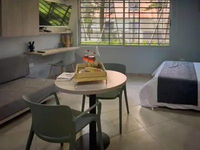 a room with a table and a bed and a table and chairs at Loft moderno con bañera Medellín 1-03 in Medellín