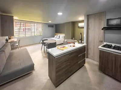 a kitchen and living room with a couch and a table at Loft moderno con bañera Medellín 1-03 in Medellín