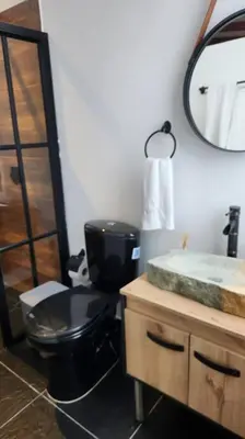 a bathroom with a toilet and a sink and a mirror at Nuevo Loft en el Poblado in Medellín