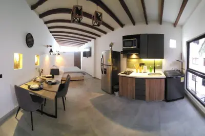 a kitchen and living room with a table and a refrigerator at Nuevo Loft en el Poblado in Medellín