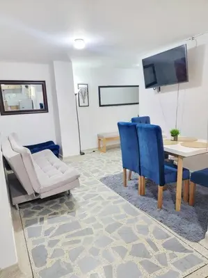 a living room with a table and chairs and a tv at Exclusivo apartamento en Estadio in Medellín