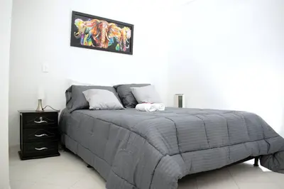 a bedroom with a bed with a gray comforter at Exclusivo apartamento en Estadio in Medellín