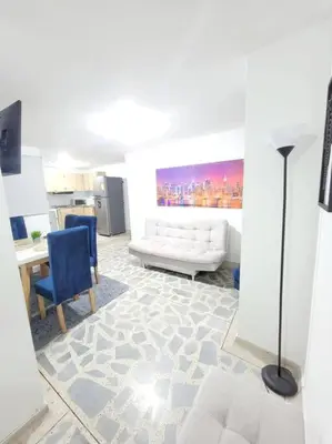 a living room with a white couch and blue chairs at Exclusivo apartamento en Estadio in Medellín