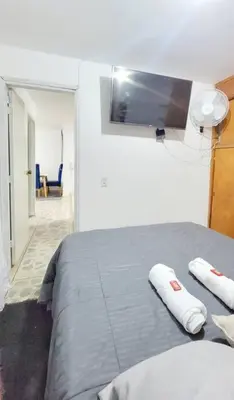 a bedroom with a bed with a tv on the wall at Exclusivo apartamento en Estadio in Medellín