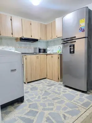 a kitchen with a white refrigerator and wooden cabinets at Exclusivo apartamento en Estadio in Medellín