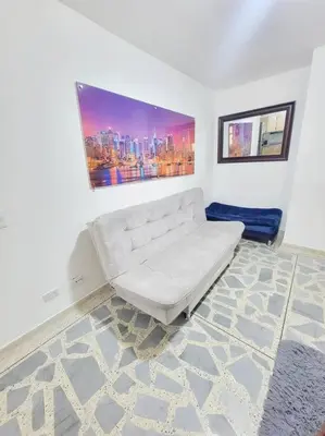 a white couch in a room with a painting on the wall at Exclusivo apartamento en Estadio in Medellín
