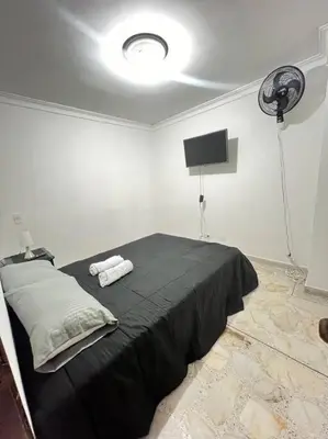 a bedroom with a black bed and a fan at exclusivo apartamento laureles in Medellín