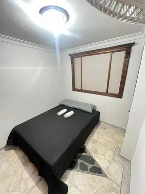 a bedroom with a black bed with two slippers on it at exclusivo apartamento laureles in Medellín