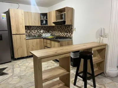 a kitchen with a wooden table and a refrigerator at exclusivo apartamento laureles in Medellín