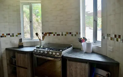 a kitchen with a stove and a counter top at Pájaros y Mariposas Casa Campestre in La Rochela