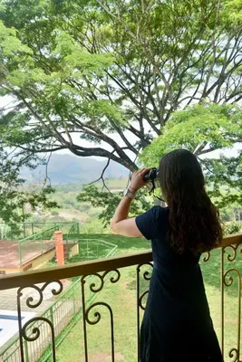 a woman taking a picture of a view from a balcony at Pájaros y Mariposas Casa Campestre in La Rochela