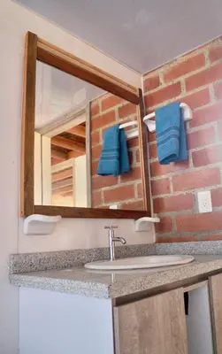 a bathroom with a sink and a mirror at Pájaros y Mariposas Casa Campestre in La Rochela