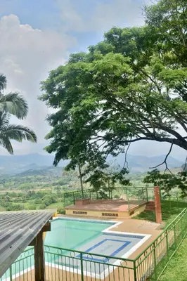 a swimming pool with a view of a tree at Pájaros y Mariposas Casa Campestre in La Rochela