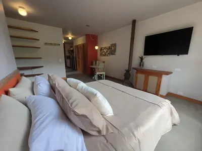 a bedroom with a large white bed with pillows at Son de la Loma Apartments in Envigado