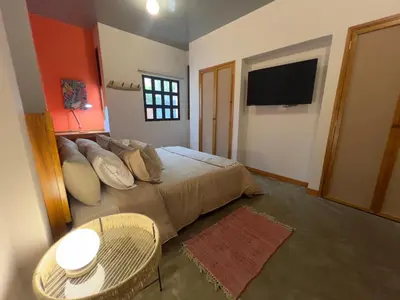 a bedroom with a bed with a television and a table at Son de la Loma Apartments in Envigado