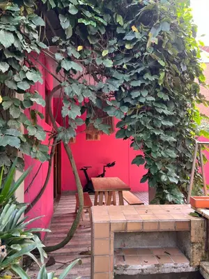 a wooden deck with a bench and a red wall at Son de la Loma Apartments in Envigado
