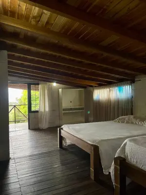 a bedroom with a large bed and a wooden floor at Hermosa casa finca en Marinilla in Marinilla