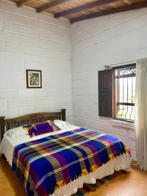 a bedroom with a bed with a colorful blanket at Hermosa casa finca en Marinilla in Marinilla
