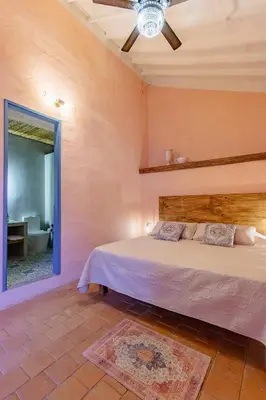 a bedroom with a bed and a mirror at Casa la batuta in Santa Fe de Antioquia