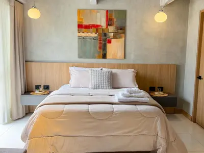 a bedroom with a large bed with two side tables at Reposso Studio Poblado in Medellín