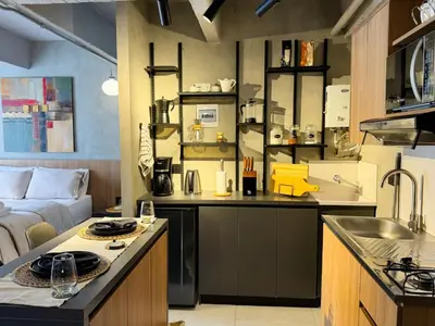 a kitchen and living room with a sink and a couch at Reposso Studio Poblado in Medellín